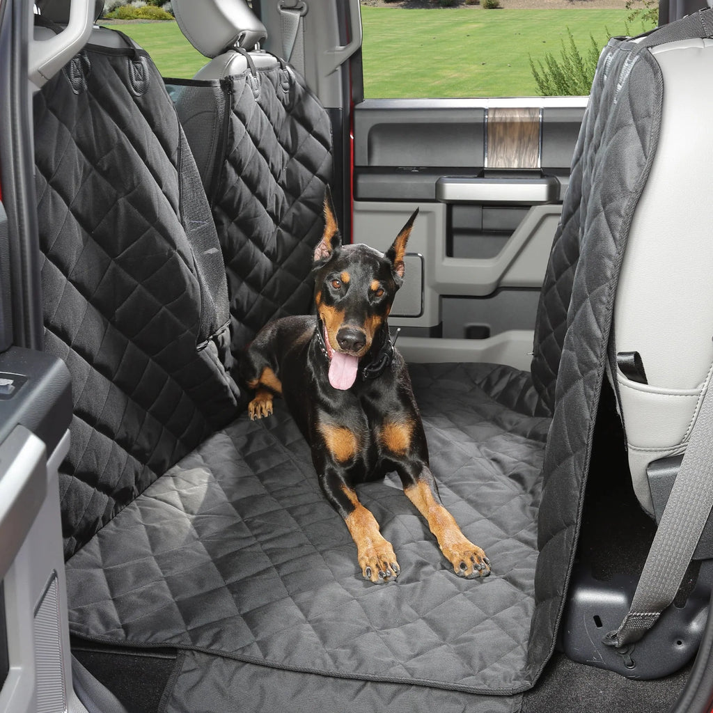 Doberman lying on a black 4Knines Floor Hammock covering the floor of a crew cab truck with the rear seats folded up