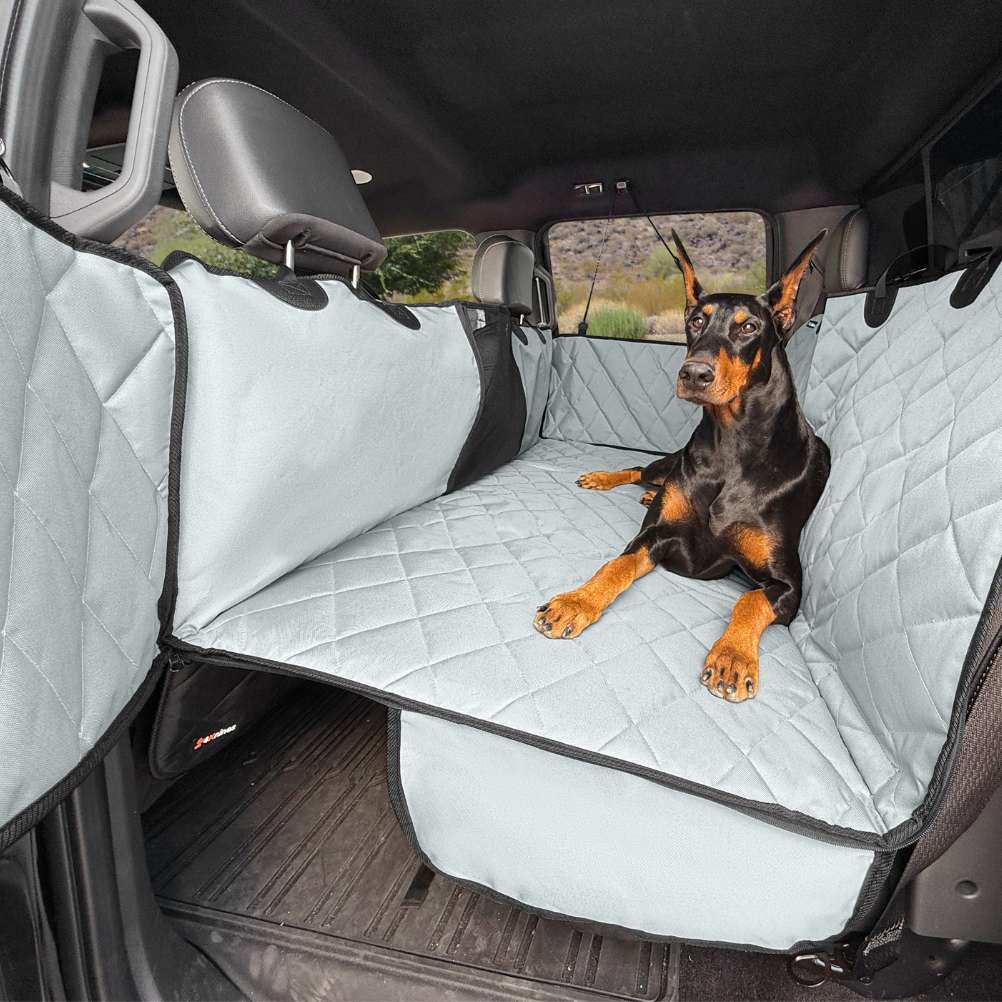 Doberman resting on a grey 4Knines extender, with the zip-open door panels on both sides