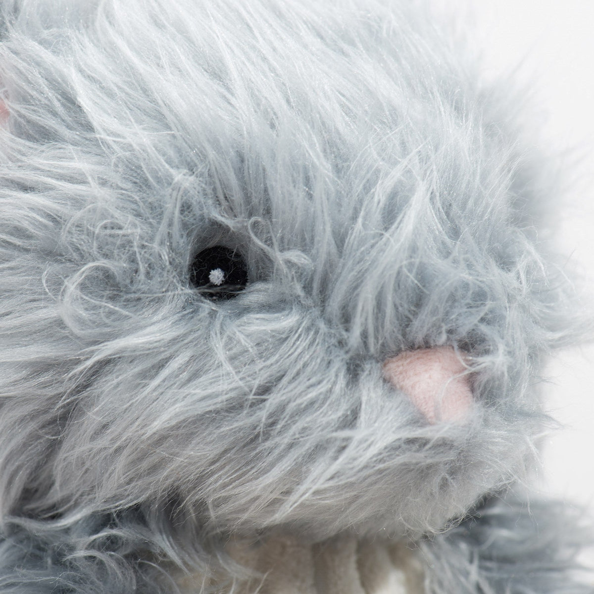 Close-up of the bunny toy's face with a pink nose and black eye