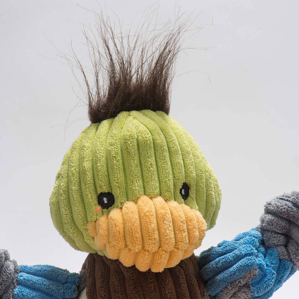 Close-up of the duck toy's green corduroy head with a hair tuft and yellow beak