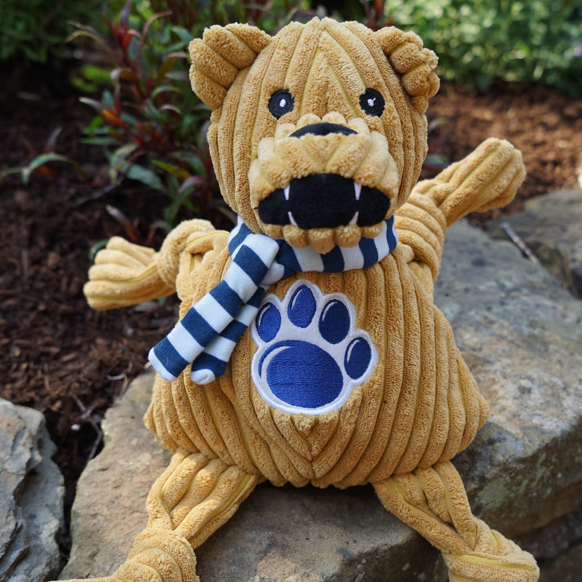 Nittany Lion Knottie toy sitting on a rock outdoors