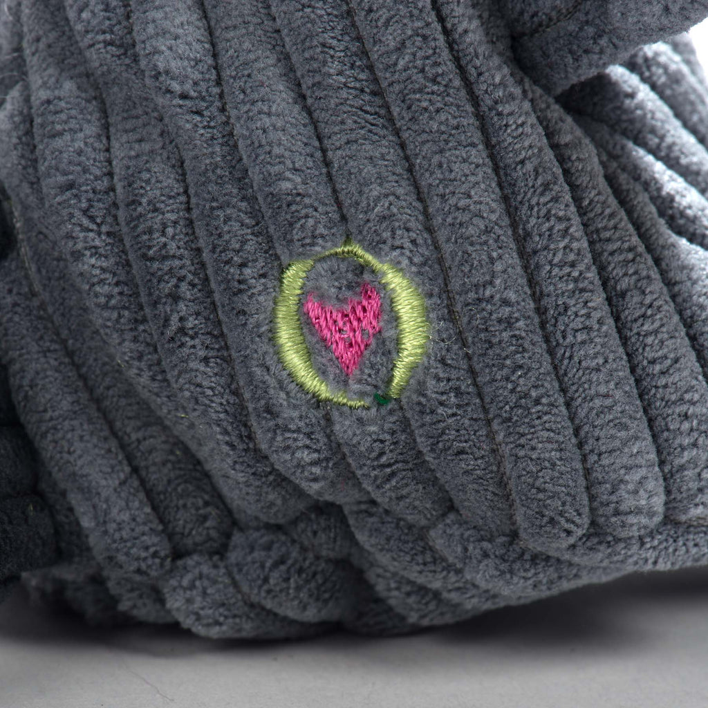 Close-up of the embroidered heart patch on the raccoon toy's corduroy body