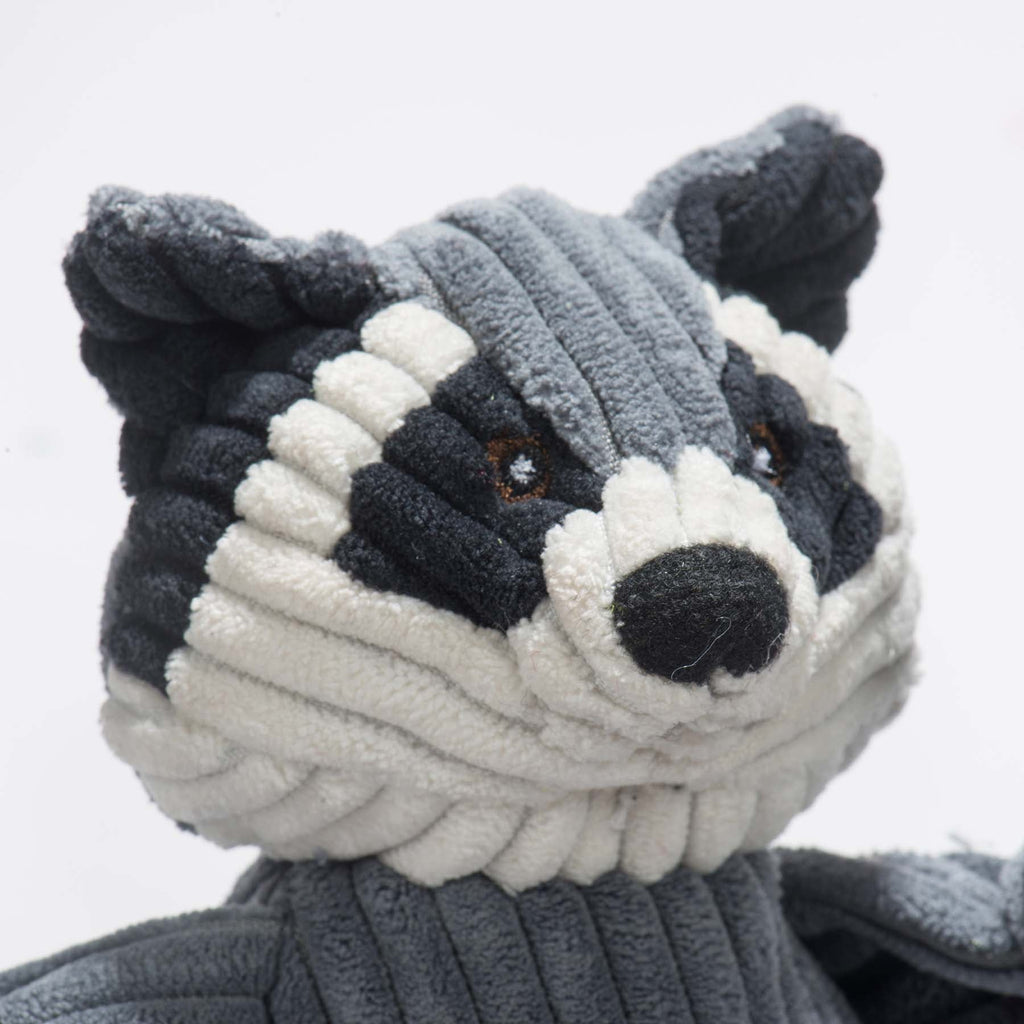 Close-up of the raccoon toy's face with black and white corduroy markings