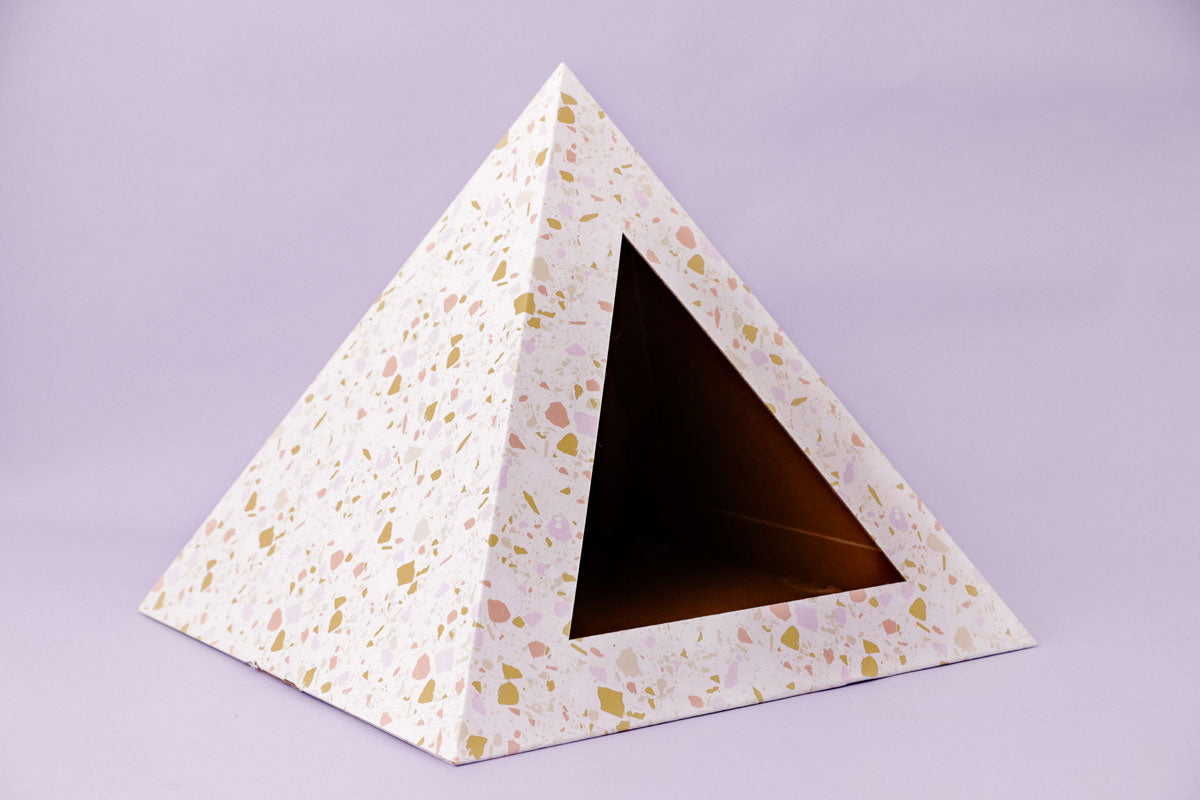 Empty terrazzo-pattern cardboard cat pyramid on a lilac background