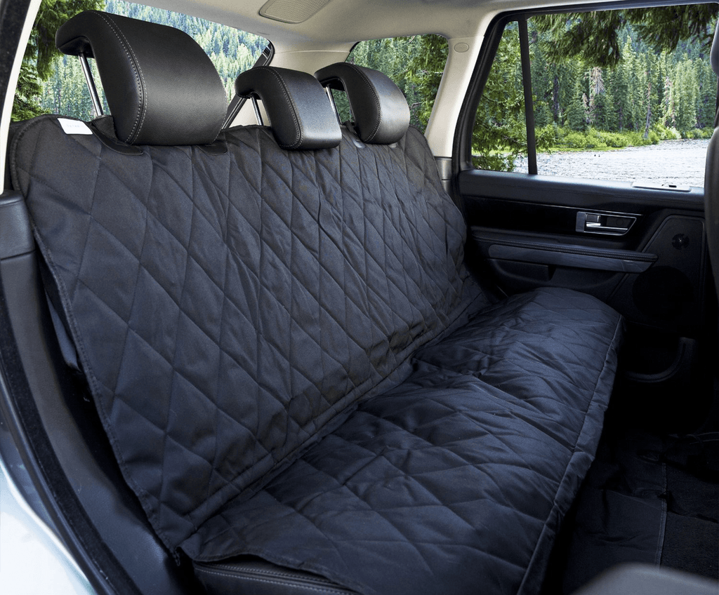 Close view of the black quilted cover on a car's back seat with straps around the headrests