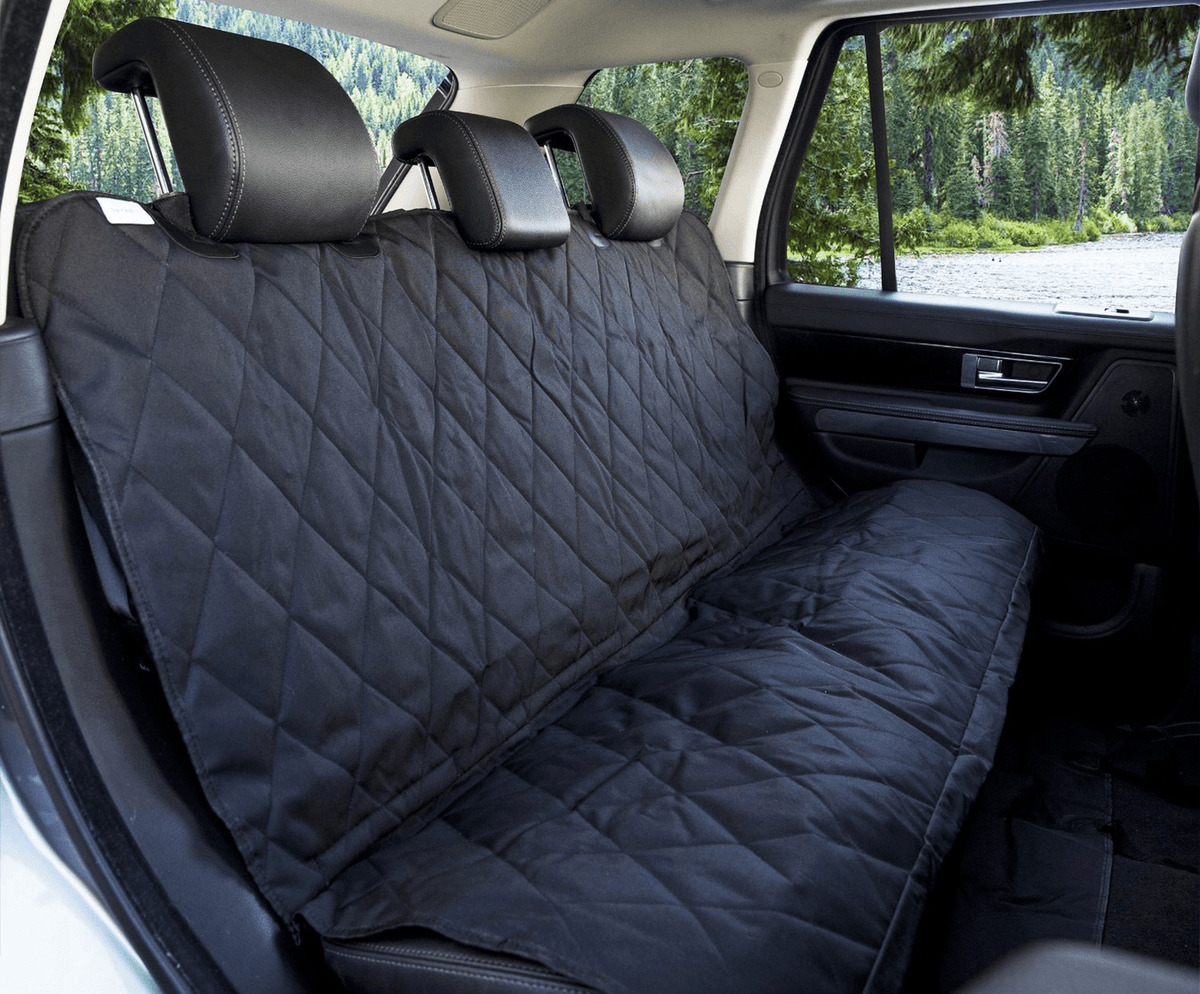 Close view of the black quilted cover on a car's back seat with straps around the headrests