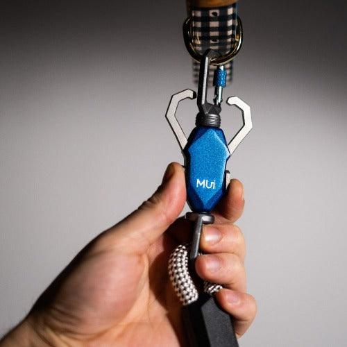 Hand holding the blue magnetic leash latch next to a collar
