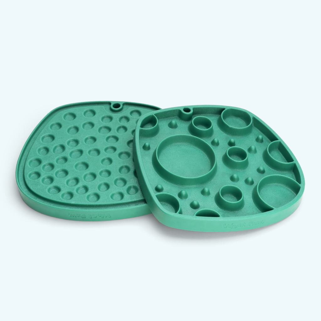 Two green feeding mats with round wells and raised dots