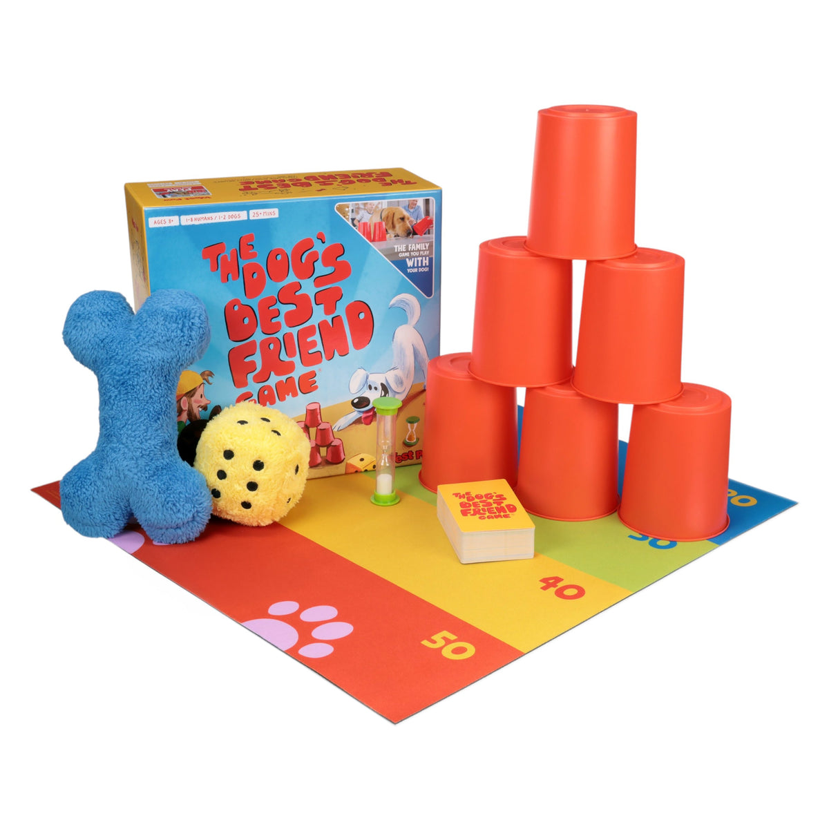 The game set up: a blue plush bone, a yellow plush die, stacked orange cups, cards and a timer on a play mat