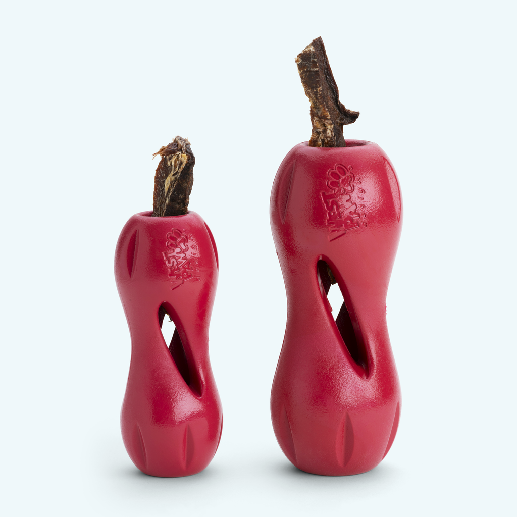 Two red hourglass treat toys standing upright, each with a chew in the top