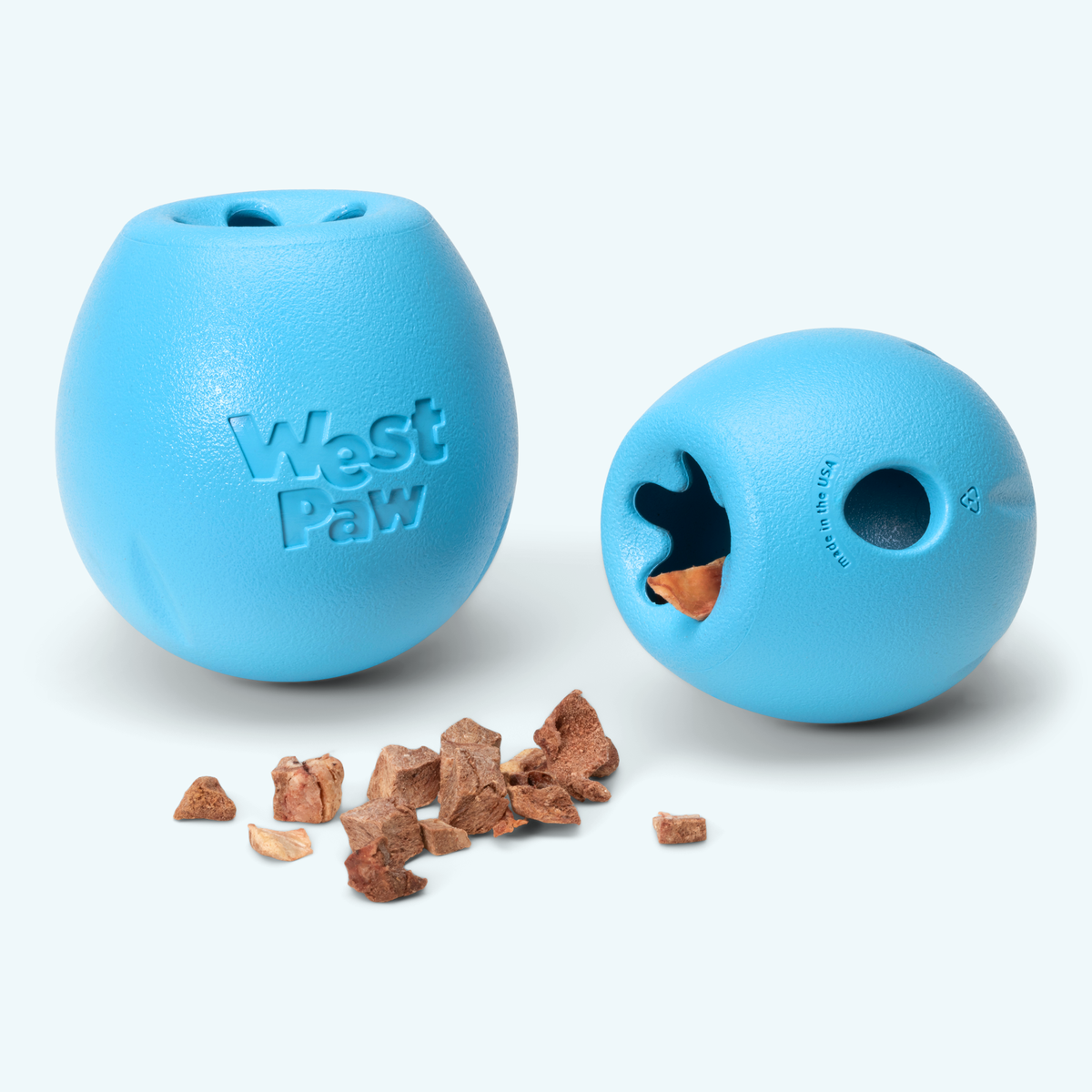 Two blue egg-shaped treat toys, one showing a treat inside