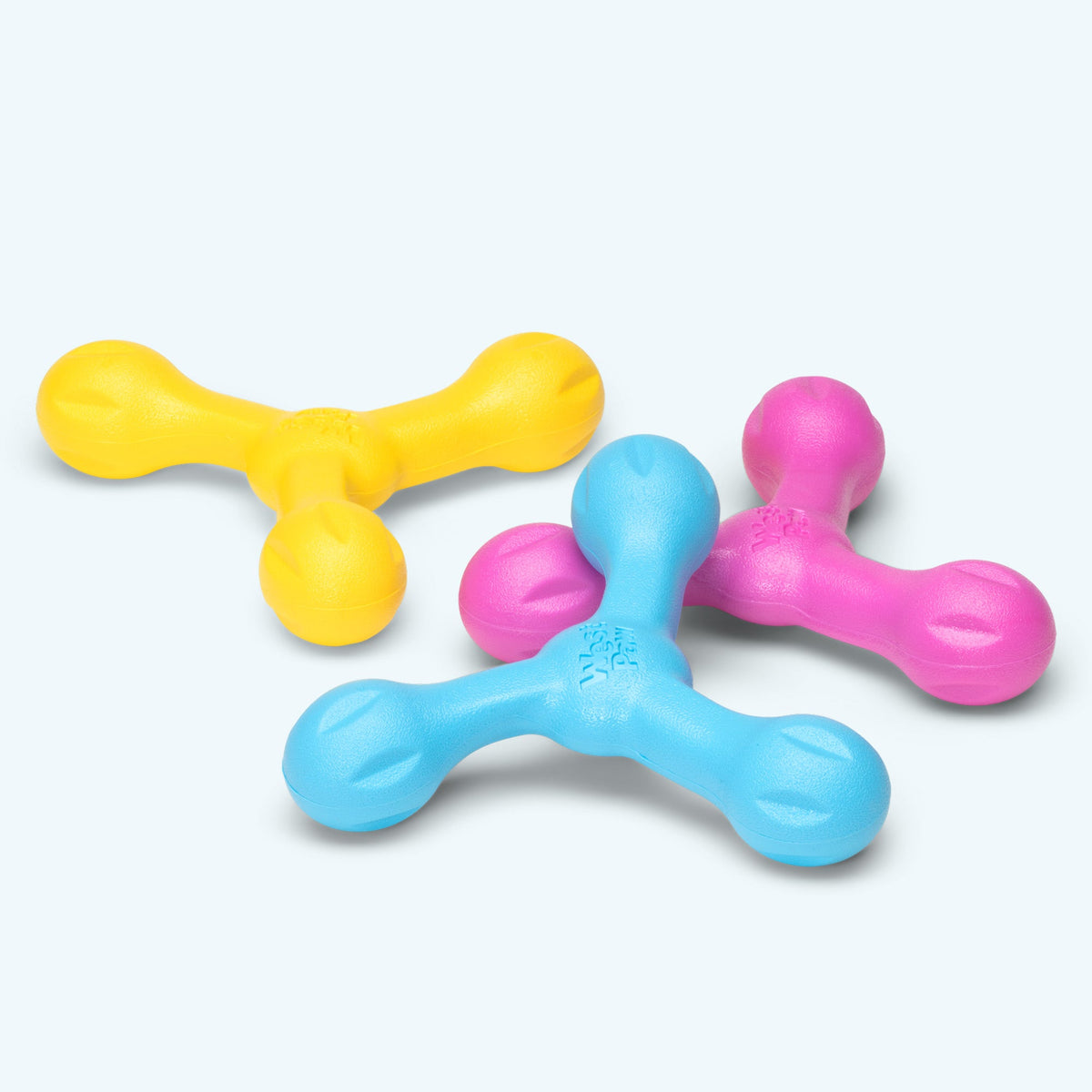Three-armed rubber fetch toys in yellow, blue and pink
