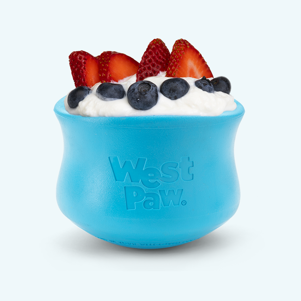 Blue pot-shaped treat toy filled with yogurt, strawberries and blueberries
