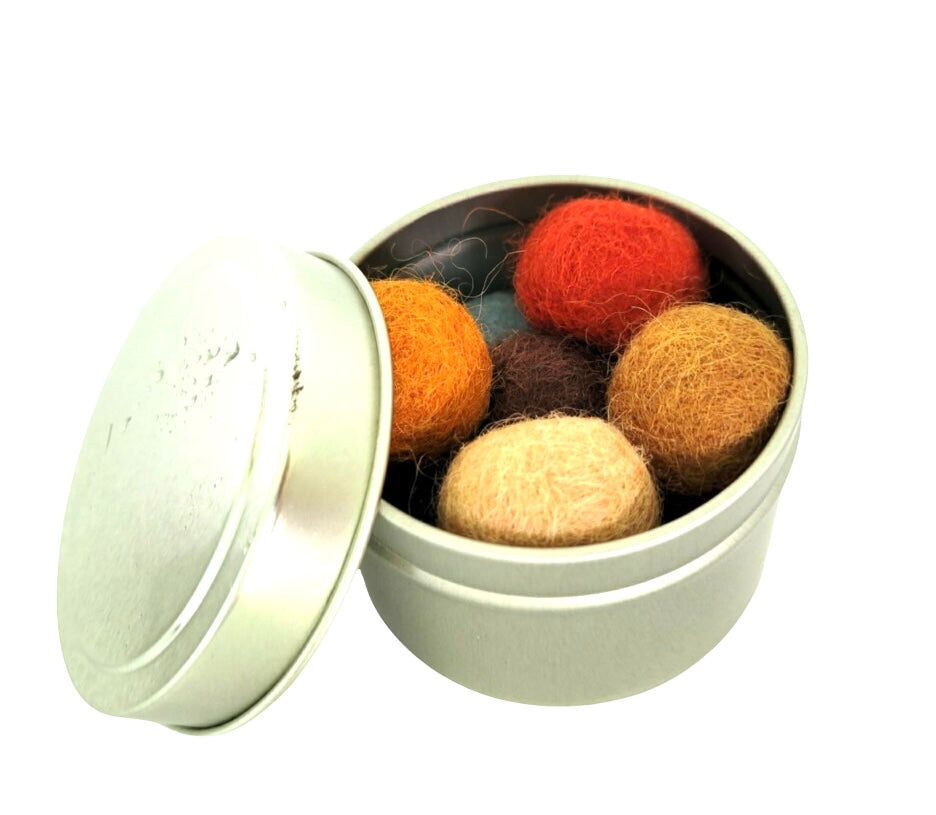 Round tin of felted wool cat balls in orange, red and tan